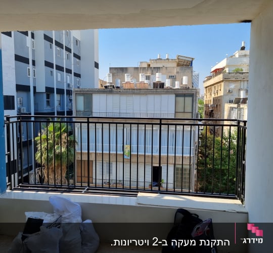 מעקה ברזל שחור במרפסת עם נוף לבניינים